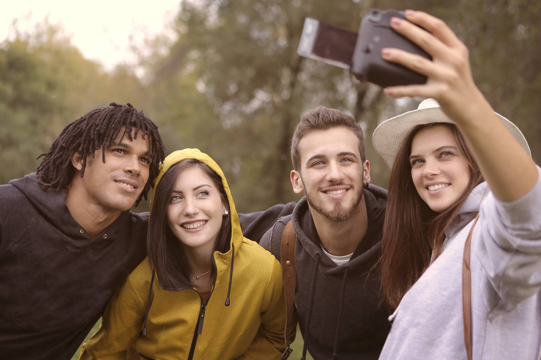 happy diverse friends taking selfie in park